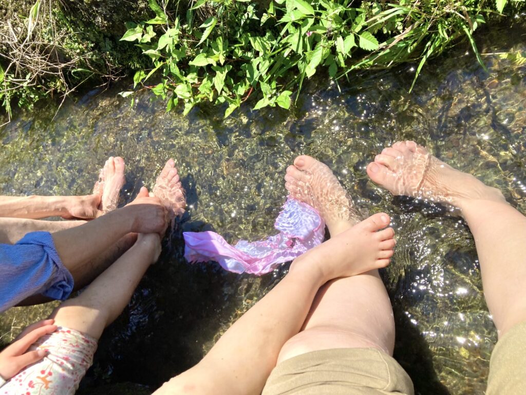 用水路に家族で足をつけて涼む写真